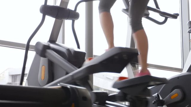 woman legs running on Elliptical Workout Gym