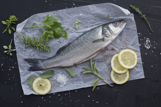 Food: Raw Fish, Loup de mer, sea perch being prepared with herbs