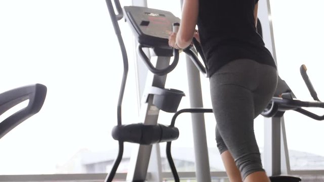 young woman at the gym exercising on the xtrainer machin