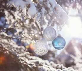 Three christmas ornaments on the fir branch outdoor with  snow