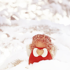 Christmas decoration wooden angel with a heart on the snow