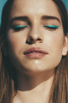 Sunlit face of a young woman with closed eyes