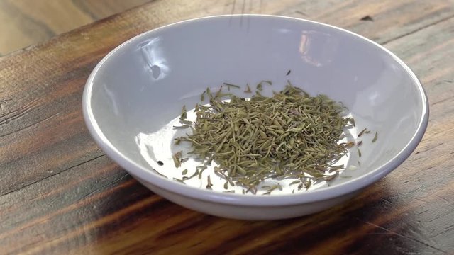 Pouring thyme into a spice dish, slow motion
