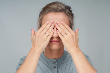 Tired woman in eyeglasses, covering face eyes hands