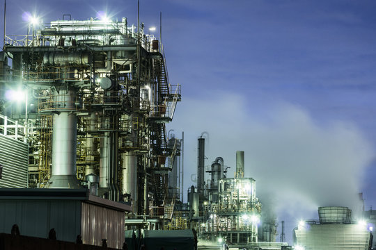 Illuminated chemical factories with smoking chimneys