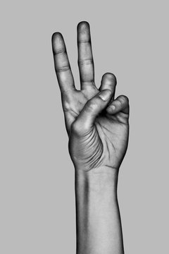 Hand making the number two sign. Black and white photo.