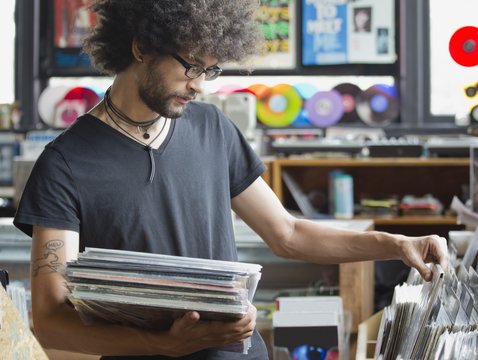 Young man browsing records in record shop