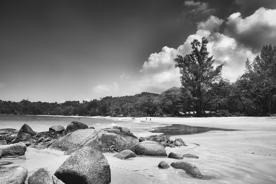 Black and white image of a beach facing storm clouds