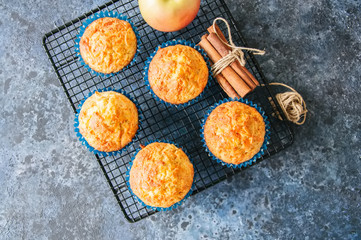 Homemade apple cheese muffins on a wire rack. Blue stone background. Seasonal baking.
