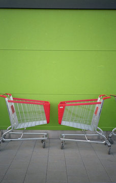 Shopping trolleys in front of green wall