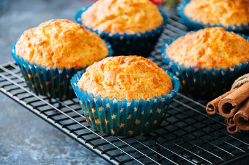 Homemade apple cheese muffins on a wire rack. Blue stone background. Seasonal baking.