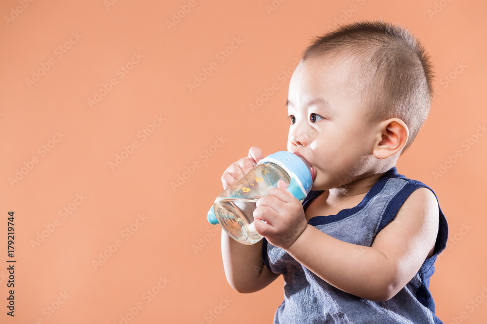 Wall mural little baby boy drink water