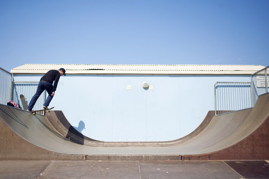 Young man skateboarding in a skate park on a sunny day