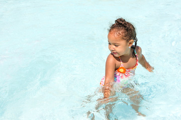 Happy young girl playing in a pool