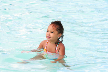 Happy young girl playing in a pool