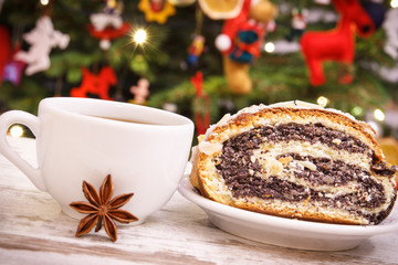 Fresh polish poppy seeds cake, coffee or tea and christmas tree with lights and decoration, Christmas time concept