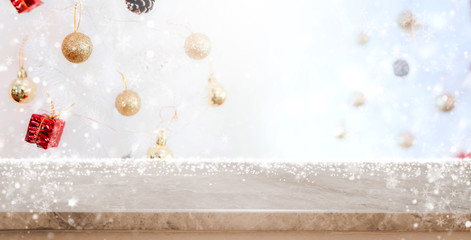 Stone marble table top on blur with bokeh christmas tree background with snowfall - can be used for display or montage your products.