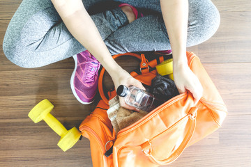 Woman with bag and fitness equipment