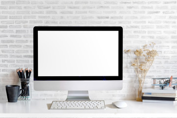 Mockup of Modern desktop computer with empty screen and stationery items on light table in workspace interior.