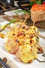 Chicken skewer with cheese on white plate