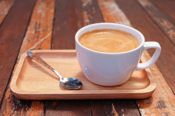 Hot coffee in white cup on wooden table