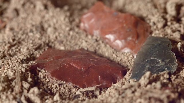 Close up of native American red arrowheads obsidian jasper chert Paiute Indian stone tool in dirt from Oregon great basin desert