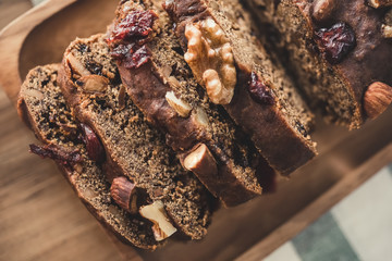Close up of delicious homemade low sugar dried fruit cake with healthy mixed nuts on wooden plate