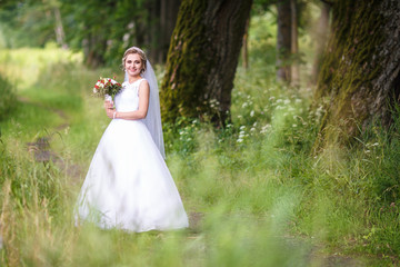 joyful and happy bride in an oak grove