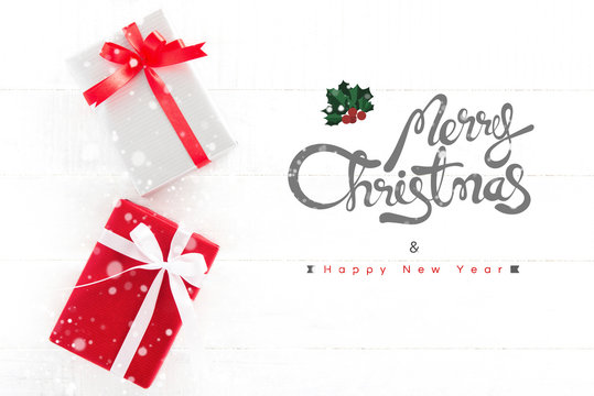 Merry Christmas and Happy New Year text with gift boxes on white wood background