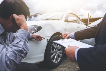 Man agent Filling Insurance Form Near Damaged and examining Car, Traffic Accident and insurance...