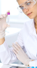 Female scientific researcher in laboratory studying substances or blood sample. Medicine and science concept