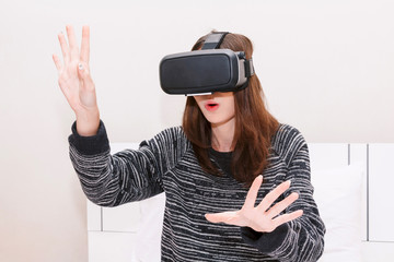 Young woman enjoy with virtual reality glasses at home