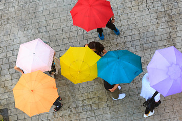 People hidden under umbrella in rainy day