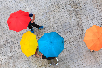 People hidden under umbrella in rainy day