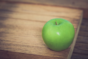 Green apple on wooden background .