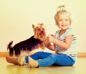 Cute little girl with yorkshire terrier indoor