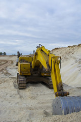 old abandoned yellow excavator in sandpit