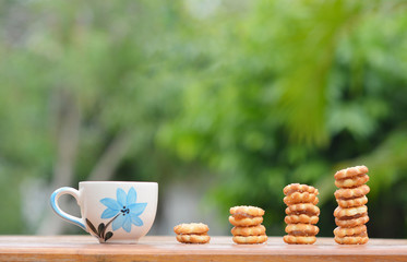 A cup of coffee with cookies.