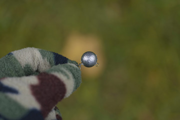  Fishing tackle in hand. The fisherman holds a sinker in hand.