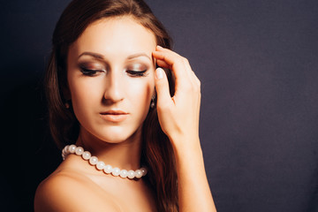 Brunette woman on a dark background close-up