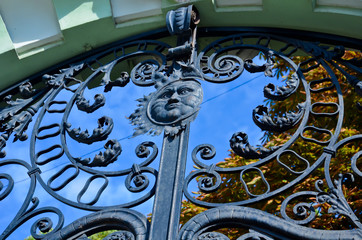 old rustic decorated gate with symbol of sun and blue sky
