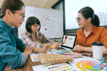 beautiful female designer team using mobile pad