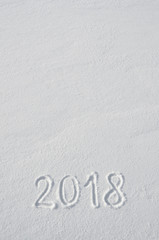 2018 text letters handwritten on flat snow surface. New year holiday seasonal postcard, greeting card template.