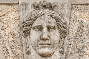 Fototapeta na wymiar Stone bas-relief with the face of the queen