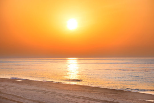 Sunset on the beach with long coastline, sun and dramatic sky © Pavlo Vakhrushev