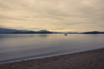 Obraz premium Boat in a lake at sunset in the Highlands of Scotland, United Kingdom; Concept for travel in Scotland