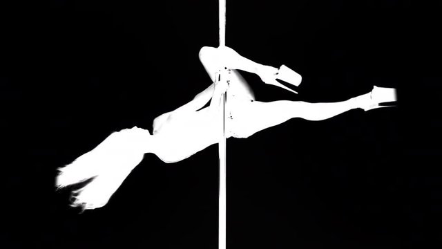 amazing pole dancer showing her skills against a black background