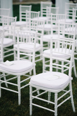 Fototapeta na wymiar Empty white chairs before wedding ceremony
