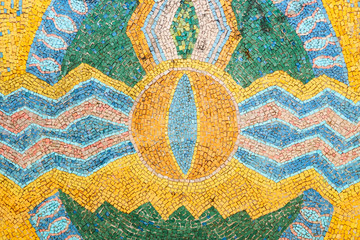 Schöner Hintergrund aus mehrfarbigen Fliesen. Mit Ziegeln gedecktes Mosaik in den Farben Blau, Grün, Gelb. Auge, Welle, Zickzack, Kreis, Vogel, Stern.