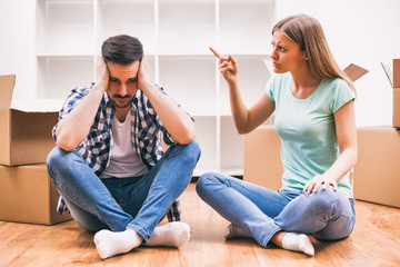 Young couple is moving in their new home. They are arguing.